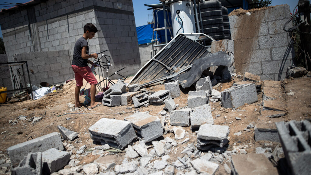 Palestinian boy inspects the damage