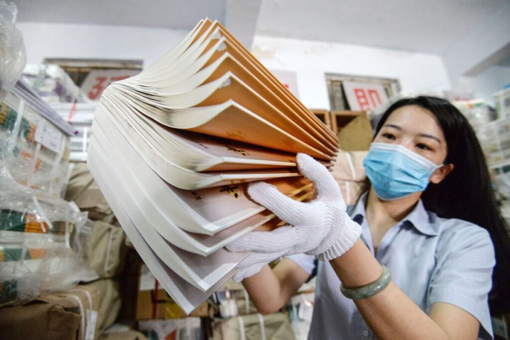 A staff member prepares textbooks at a bookstore