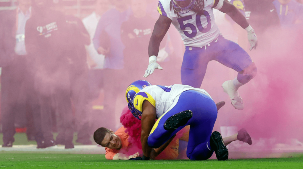 Activist Tackled By NFL Linebacker After Running Onto the Field With Smoke Bomb [VIDEO]
