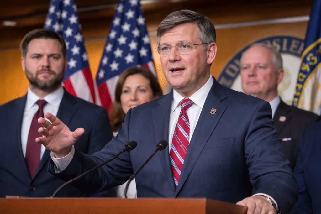 House Speaker Mike Johnson speaks at a press conference in the U.S. Capitol, flanked by Republican lawmakers with American flags visible in the background.