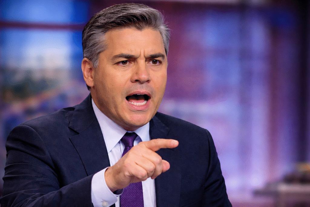 Jim Acosta speaking during a television broadcast, pointing forward while addressing a topic with a serious expression in a studio setting.