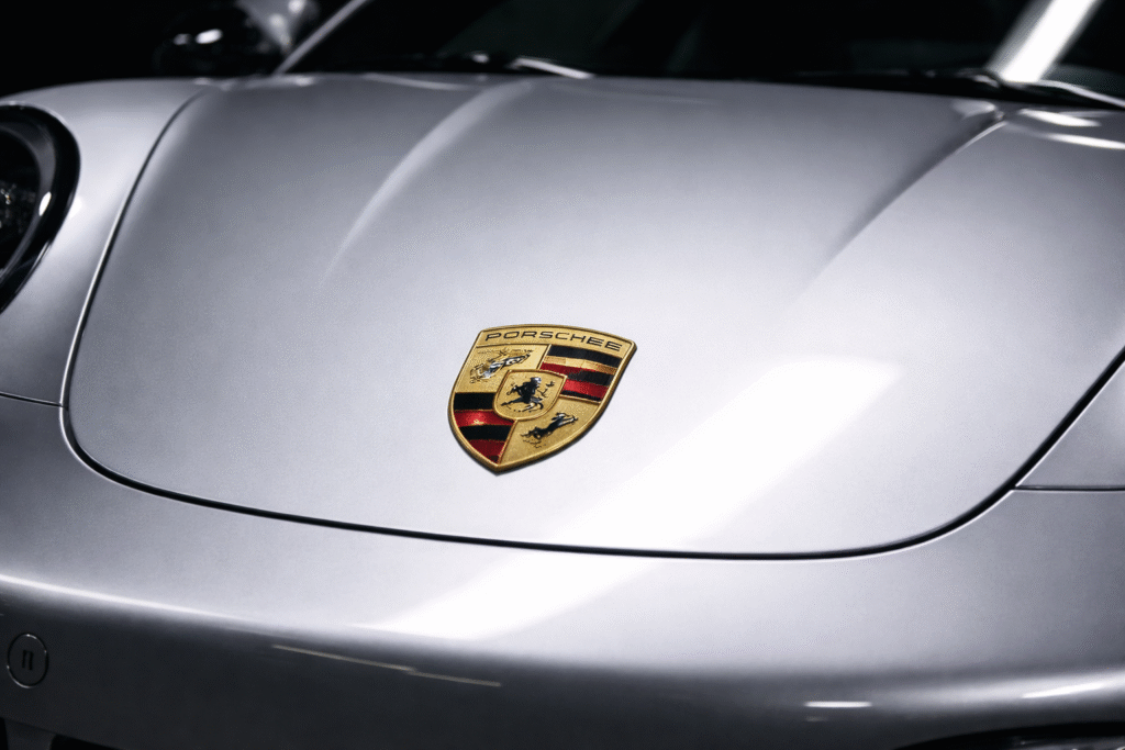 Close-up of a luxury sports car hood and front body panel photographed in studio lighting.