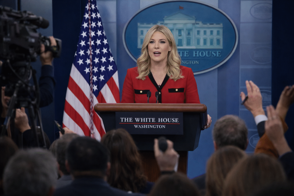 White House press briefing room with podium and reporters during a press secretary media briefing.