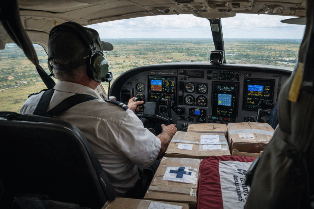 Missionary pilot flying a small humanitarian aid aircraft over rural Africa while delivering medical supplies to remote communities.