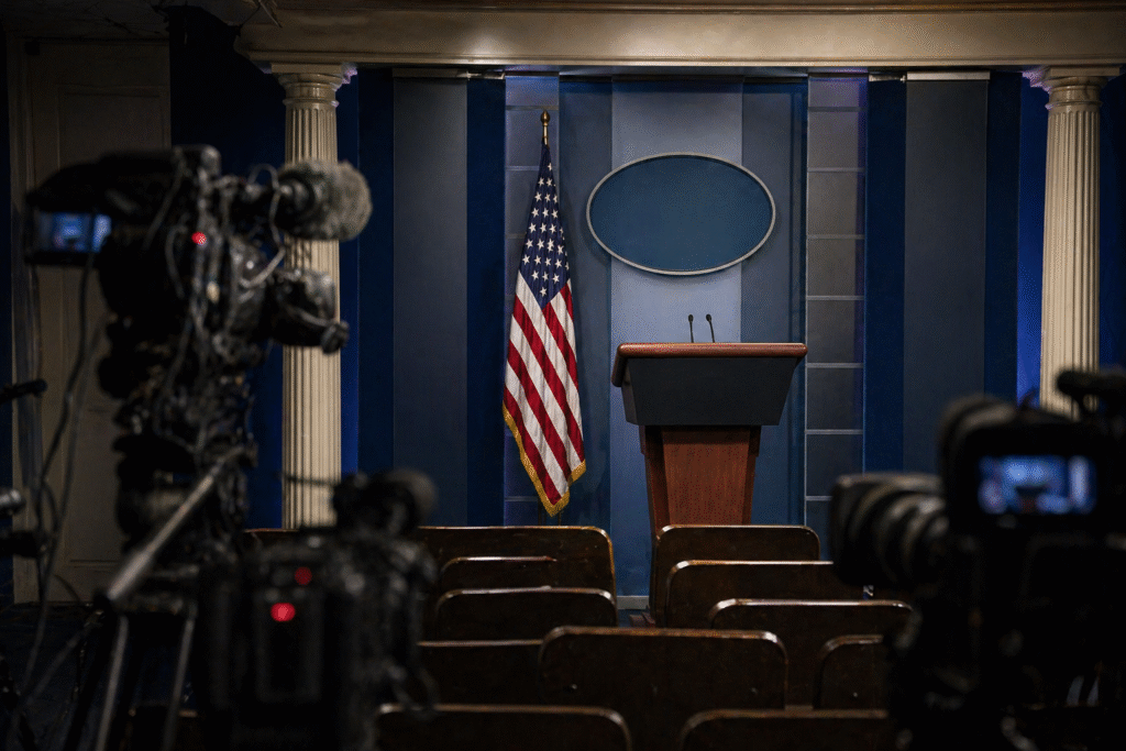 Empty press briefing room with podium and cameras representing political tension and media speculation