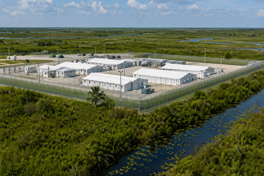 Remote detention facility surrounded by Florida wetlands with secure fencing and marshland environment visible under natural daylight.