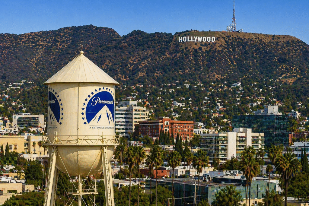 Corporate executives at a press conference representing a major media merger involving film studios, streaming services and news networks.