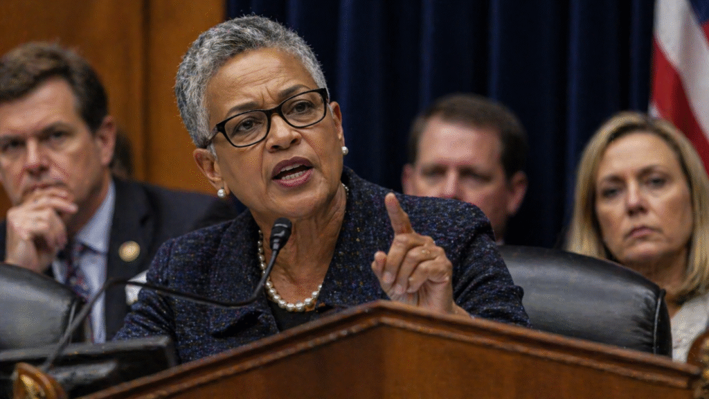 A government hearing room scene with a lawmaker speaking into a microphone while addressing officials seated behind her during a formal session