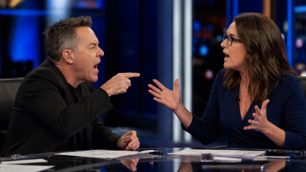 Two commentators arguing intensely across a studio desk during a live television broadcast, with expressive gestures and a blurred newsroom background