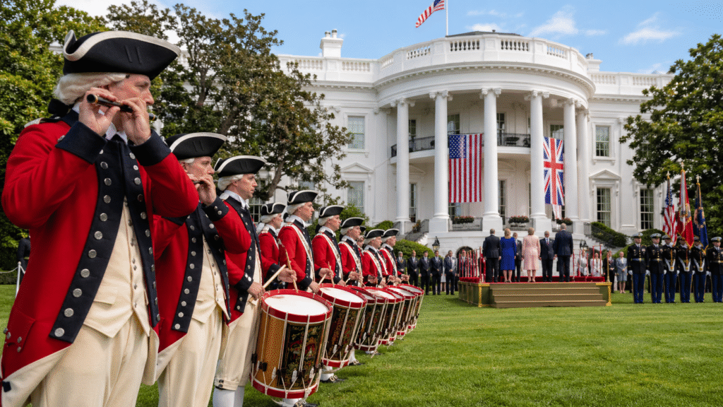 U.S. Army Old Guard Fife and Drum Corps in red colonial-era uniforms performing on the White House South Lawn during a formal state event with dignitaries present.