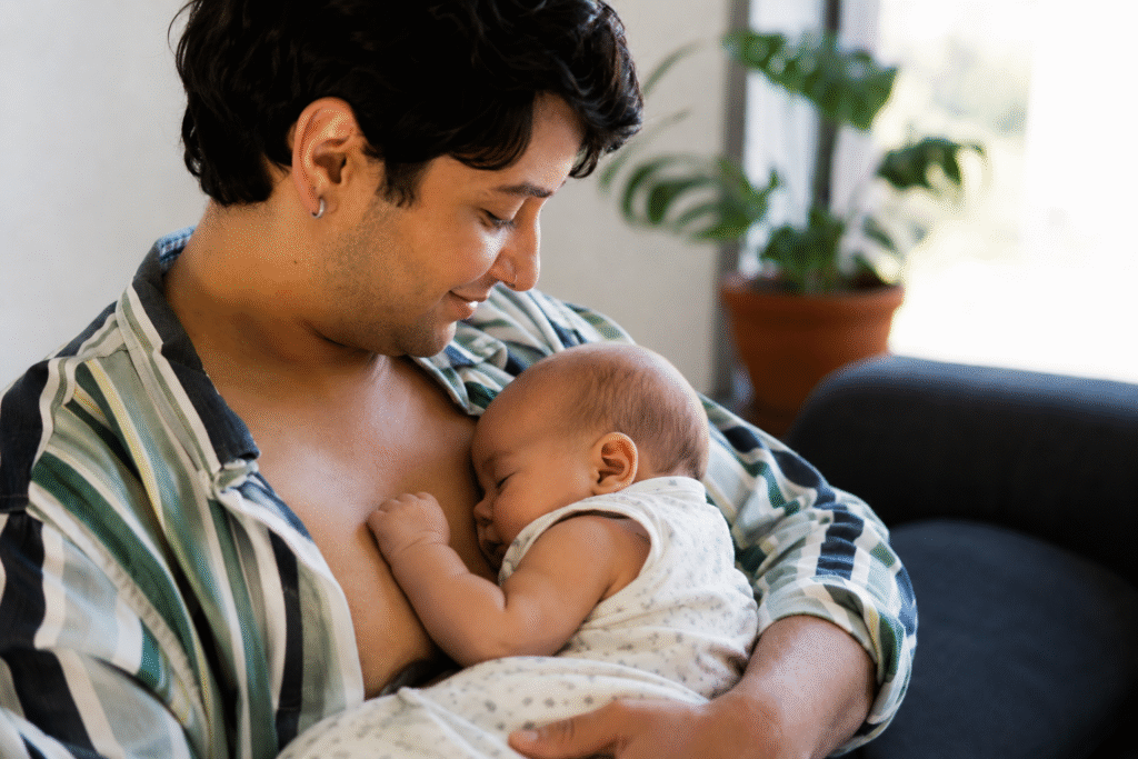 Adult nursing an infant indoors during a discussion surrounding Connecticut gender identity and parenting policy debates.