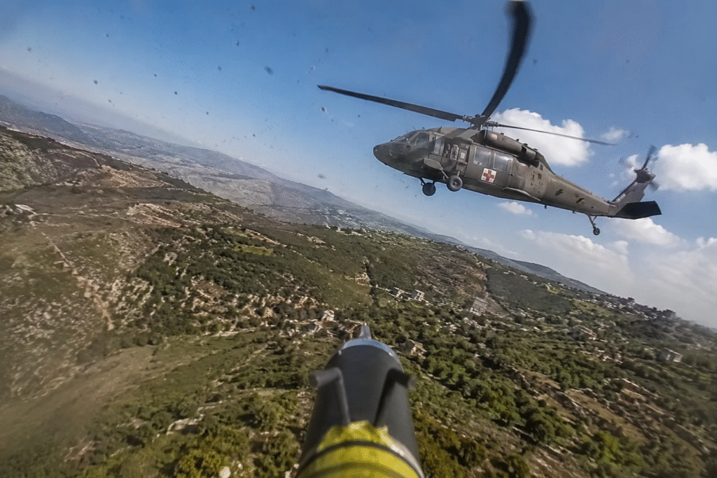 FPV drone perspective showing a military medevac helicopter flying over mountainous terrain in southern Lebanon during an active conflict zone encounter.